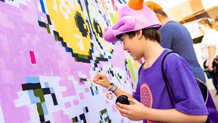 A guest paints a mural during the EPCOT Festival of the Arts