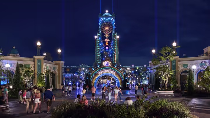 Universal Epic Universe entrance and Chronos tower illuminated at night