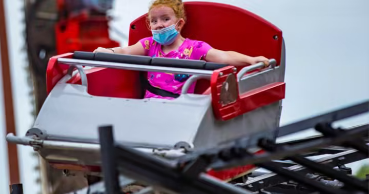 Guest riding the red and white Mad Mouse roller coaster at Arnolds Park