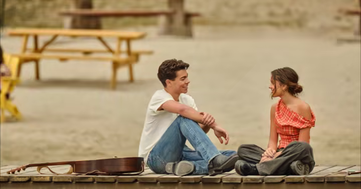 Malachi Barton and Liamani Segura sit together on a dock in Camp Rock 3