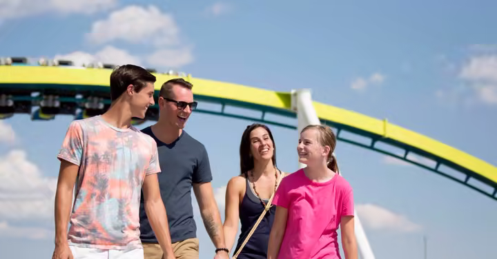 Family walking past a roller coaster at Carowinds