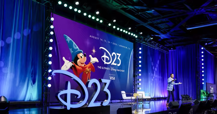 D23 stage with Sorcerer Mickey artwork and Visa branding
