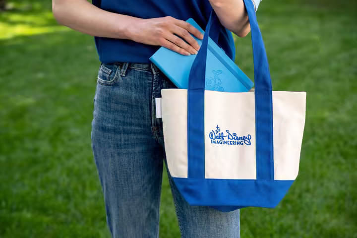 Walt Disney Imagineering tote bag and blue notebook in a Disney Parks merchandise preview