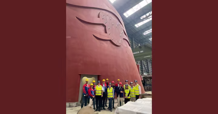 Disney Cruise Line and Imagineering team members standing beneath the unfinished Disney Believe funnel