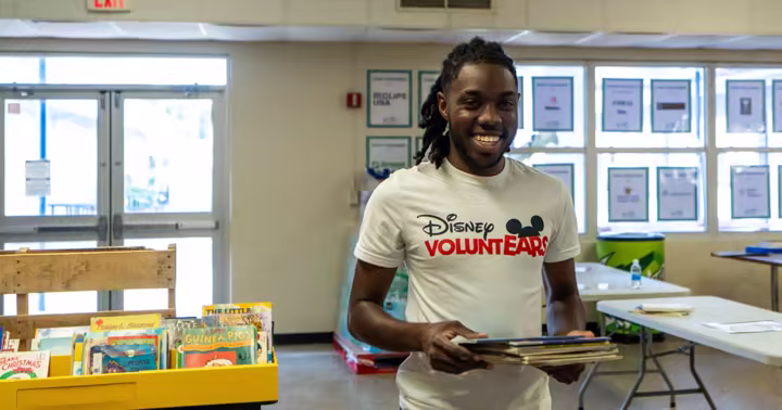 A Disney Programs student carries books at a Florida classroom supply event