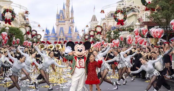 Mickey Mouse and a young performer lead the Disney Parks Christmas parade at Magic Kingdom