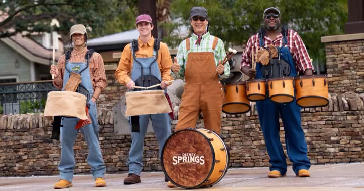 Fall performers pose beneath autumn decorations at Disney Springs