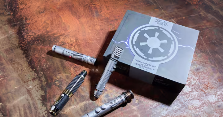 D23 Star Wars legacy lightsaber hilts and display box on a weathered metal table