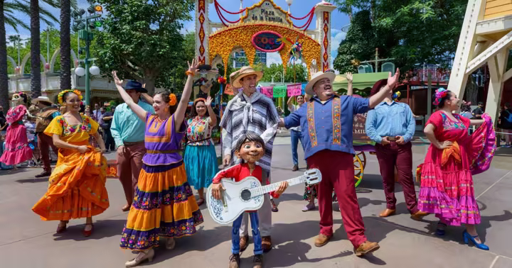 Storytellers performing in front of the Plaza de la Familia Coco arch at Disney California Adventure