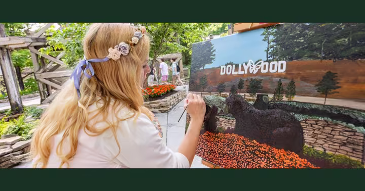 Artist Jaimie Houser paints a Dollywood entrance scene during the Flower and Food Festival