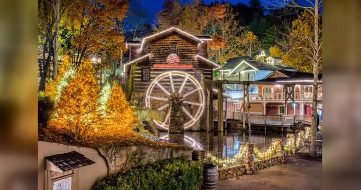 Dollywood's Grist Mill and Christmas trees covered in lights during Smoky Mountain Christmas