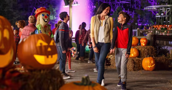 A family walks through Dollywood's glowing Great Pumpkin LumiNights displays