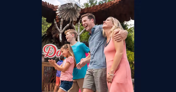 A family smiles near the Wild Eagle sculpture at Dollywood