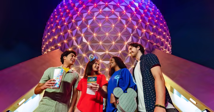 Four guests standing in front of Spaceship Earth during EPCOT After Hours