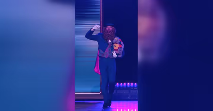 Dreamfinder carrying Figment during the D23 Disney Experiences presentation
