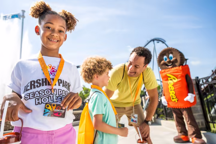 A family meets a Hersheypark character at a passholder event.