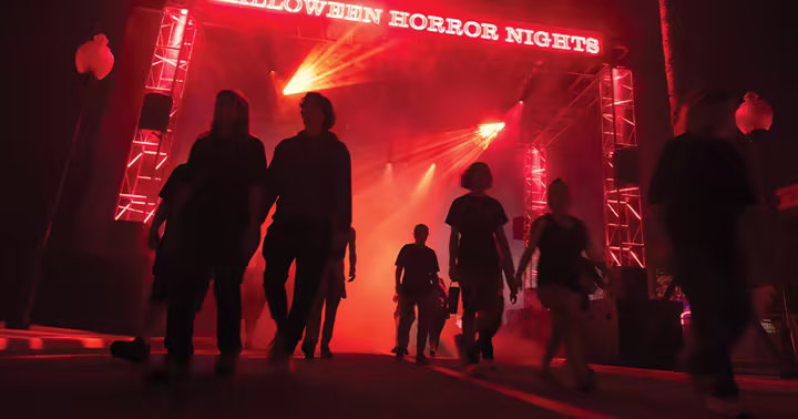 Guests enter Halloween Horror Nights under red lights