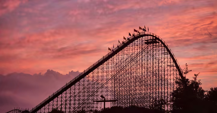 The Voyage roller coaster silhouetted against a pink sunset at Holiday World