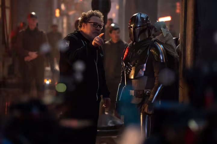 Jon Favreau directs Pedro Pascal as Din Djarin with Grogu on the set of Star Wars: The Mandalorian and Grogu