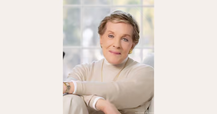Julie Andrews seated in front of a bright window