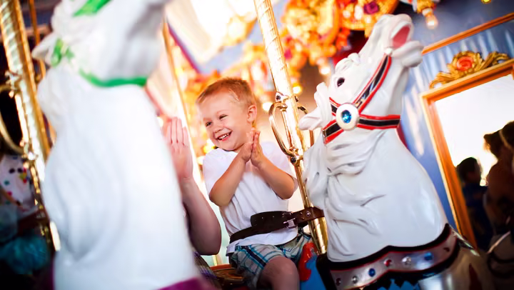 A child rides King Arthur Carrousel in Fantasyland at Disneyland Park
