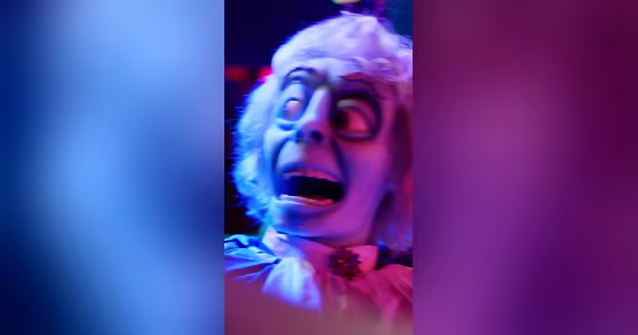 A Phantom Theater character appears in blue and magenta light at Kings Island