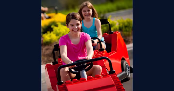 Two children drive LEGO-style cars at Driving School at LEGOLAND Florida.