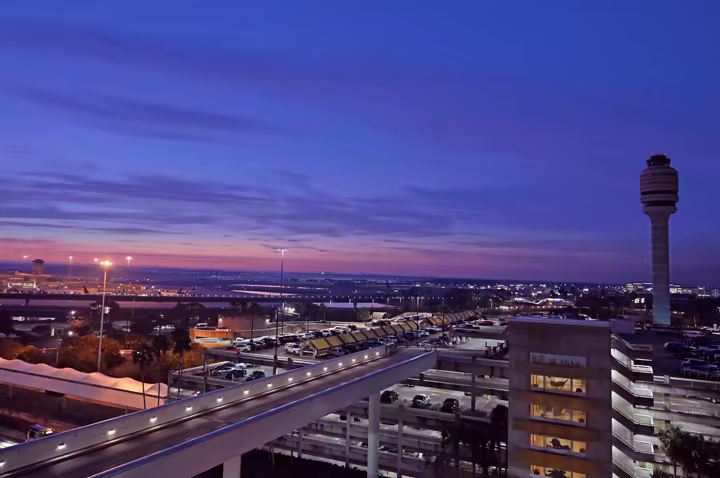 Orlando International Airport at dusk with the control tower and terminal roadways