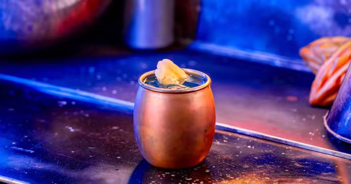 Blue Alderaanian Fizz cocktail in a metal cup at Oga’s Cantina