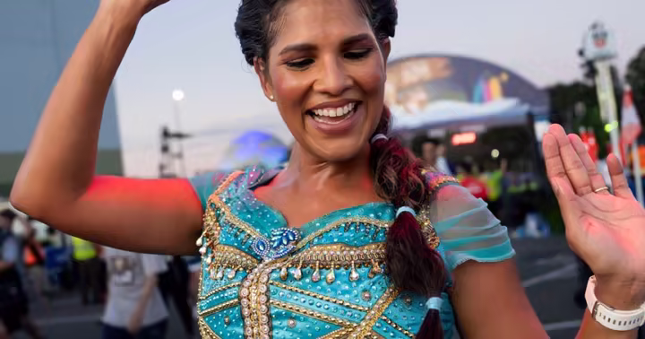 Runner dressed as Princess Jasmine waves during Disney Princess Half Marathon Weekend