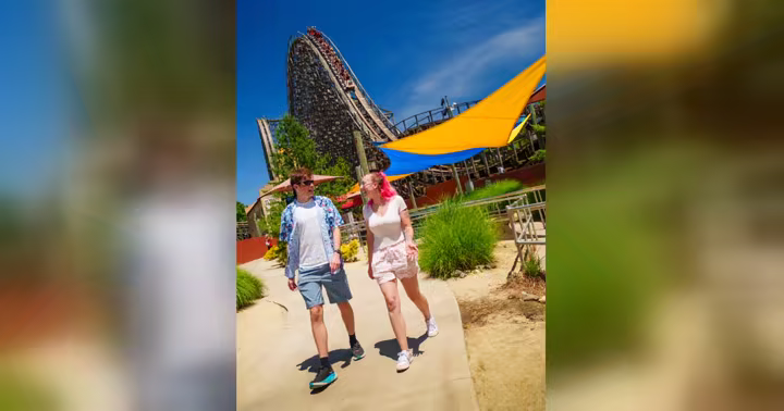 Two guests walk beside El Toro at Six Flags Great Adventure