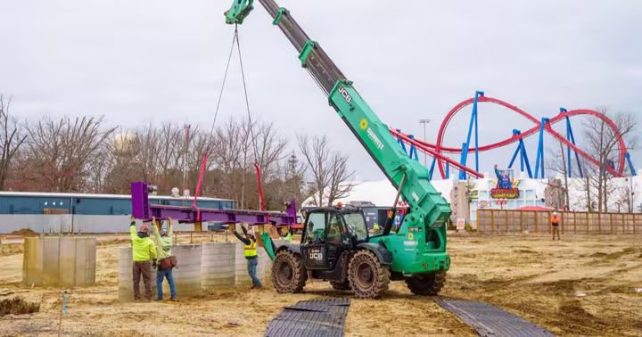 Purple roller coaster track being lifted by a crane at Six Flags Great Adventure