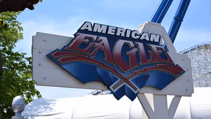 American Eagle sign at Six Flags Great America with coaster track behind it