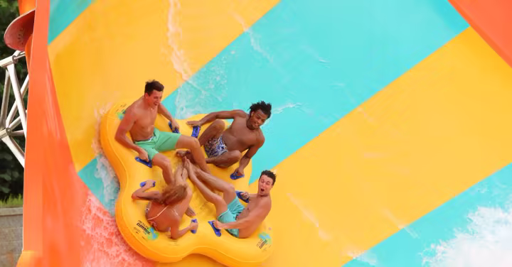 Guests ride a water slide at Hurricane Harbor Atlanta