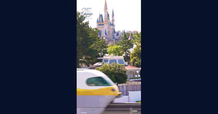 A yellow Disney Resort Line monorail passing Tokyo Disneyland during the line's 25th anniversary