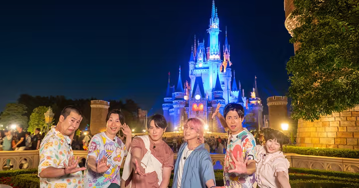 Television personalities pose in front of Cinderella Castle at Tokyo Disneyland
