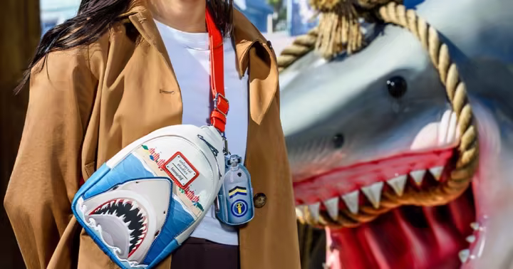 A guest posing beside a Bruce the shark display at Universal Studios Florida