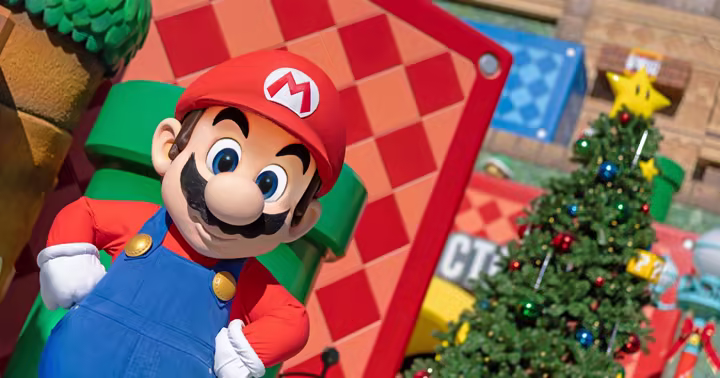 Mario beside a decorated Christmas tree in Super Nintendo World