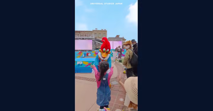Woody Woodpecker greets a child near the Universal Studios Japan parade viewing area