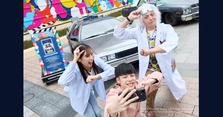 Doc Brown poses with guests and a DeLorean at Universal Studios Japan