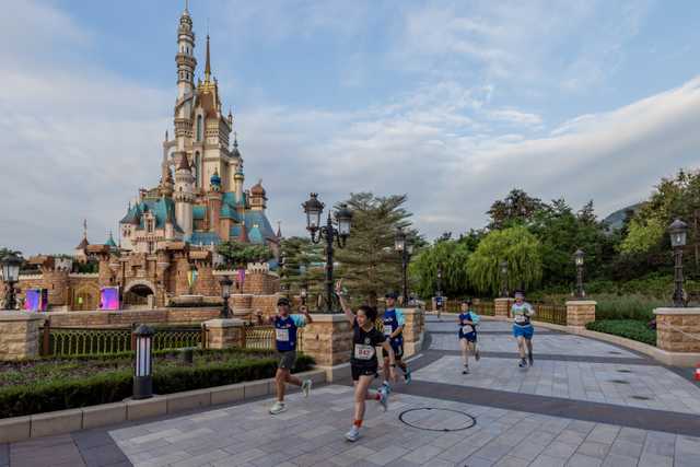 Runners pass the Castle of Magical Dreams at Hong Kong Disneyland