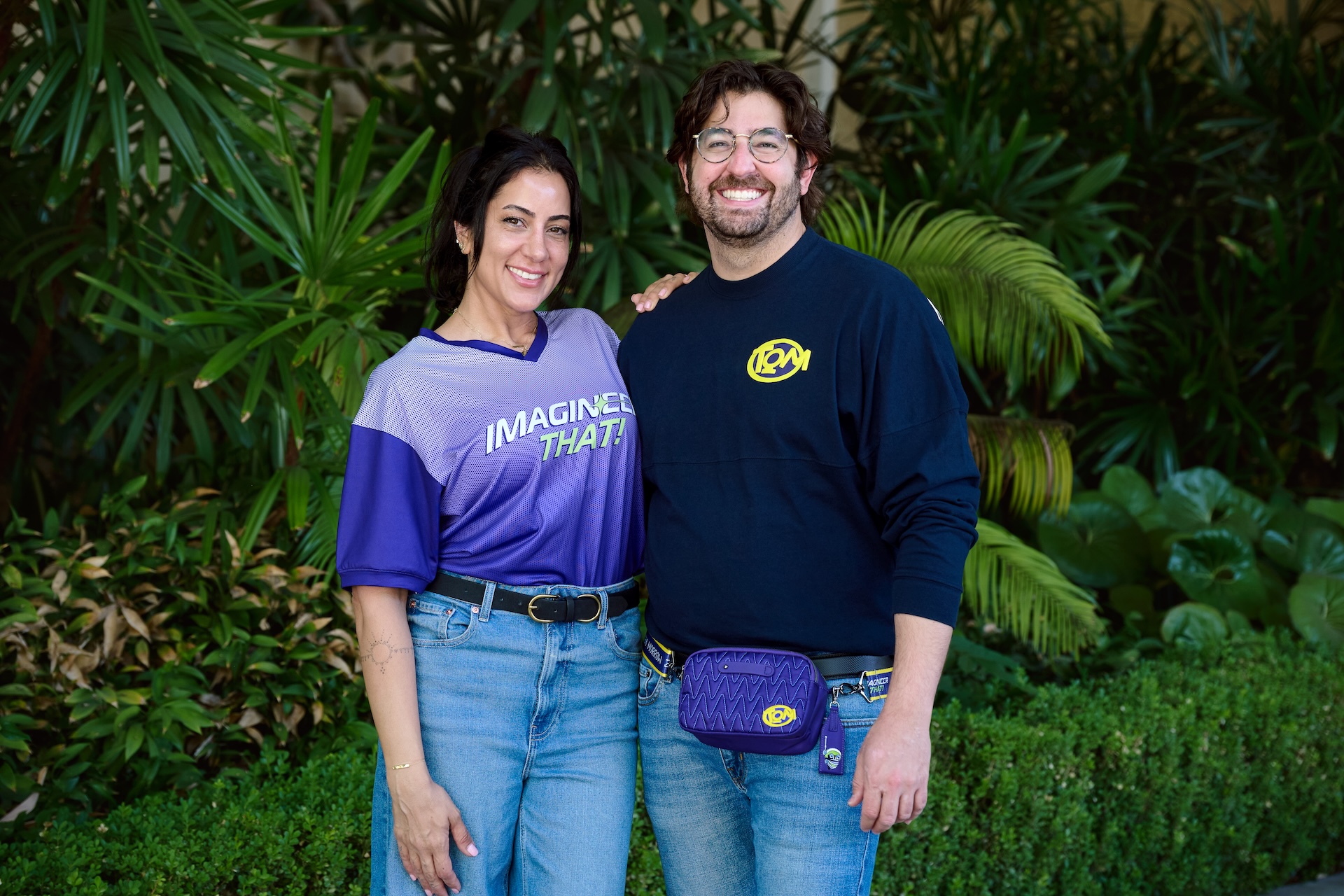 Two models wearing shirts from the Imagineer That collection for D23 2026