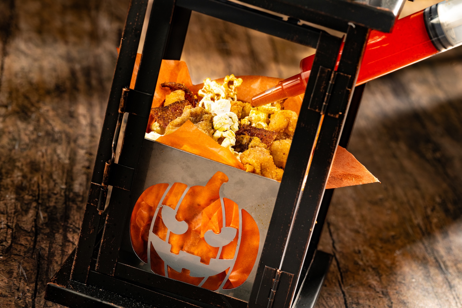 Midnight Mayhem Popcorn Chicken served in a pumpkin-sided lantern at Jock Lindsey’s Hangar Bar