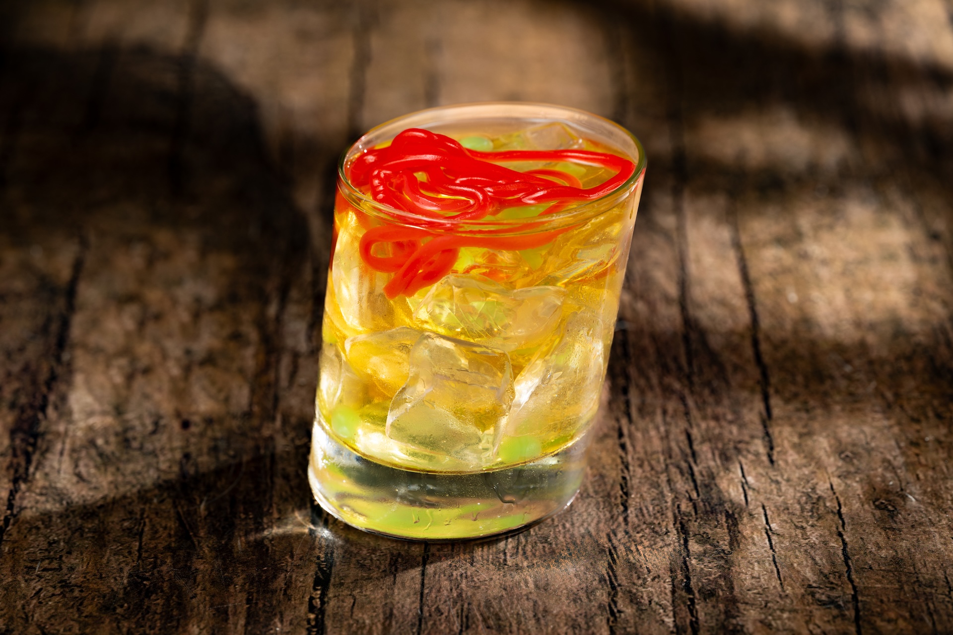 Skull and Sour cocktail with green pearls and gummy strands