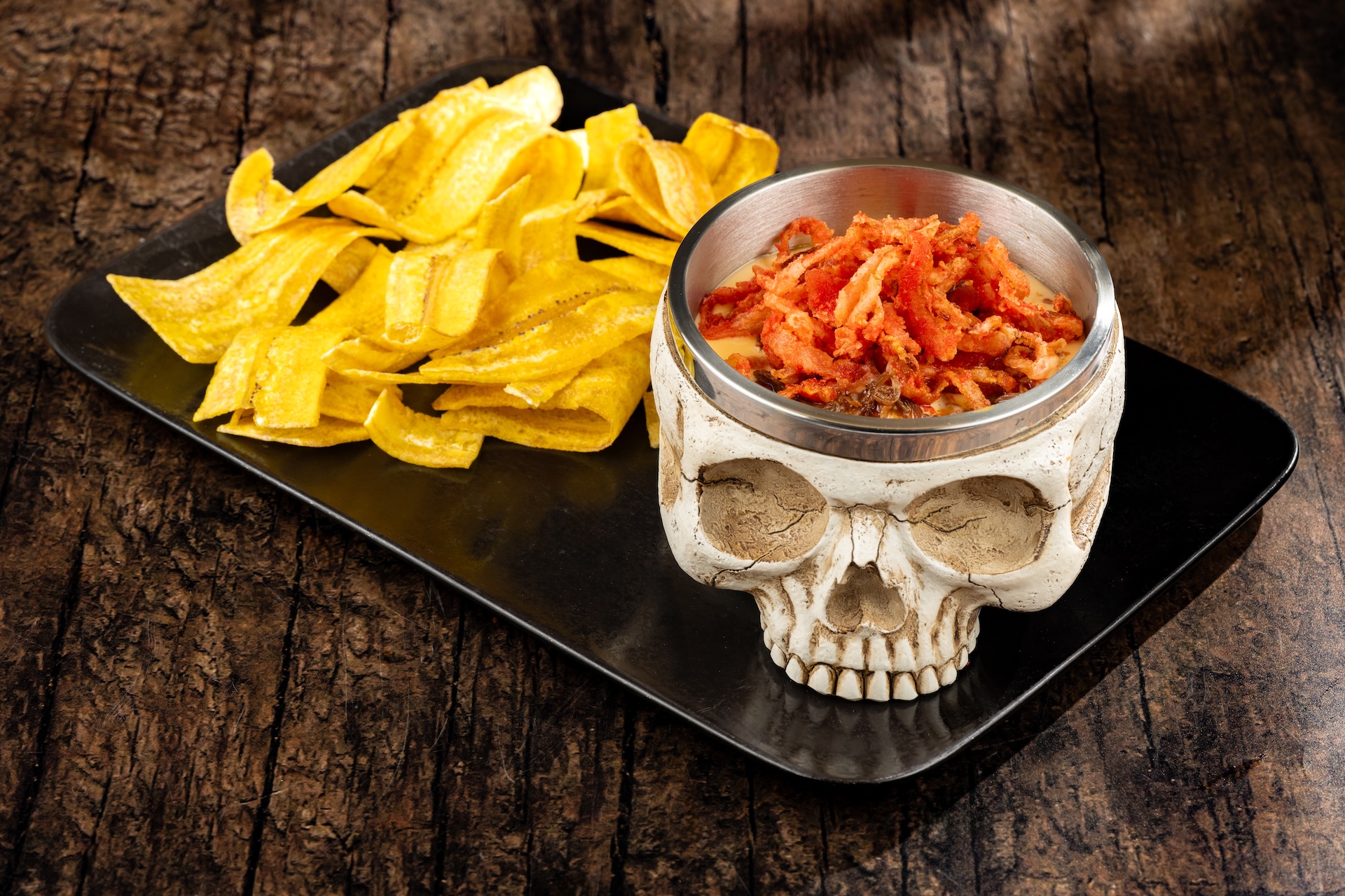 Skull of the Dead Dip with barbacoa beef, cheddar sauce and plantain chips