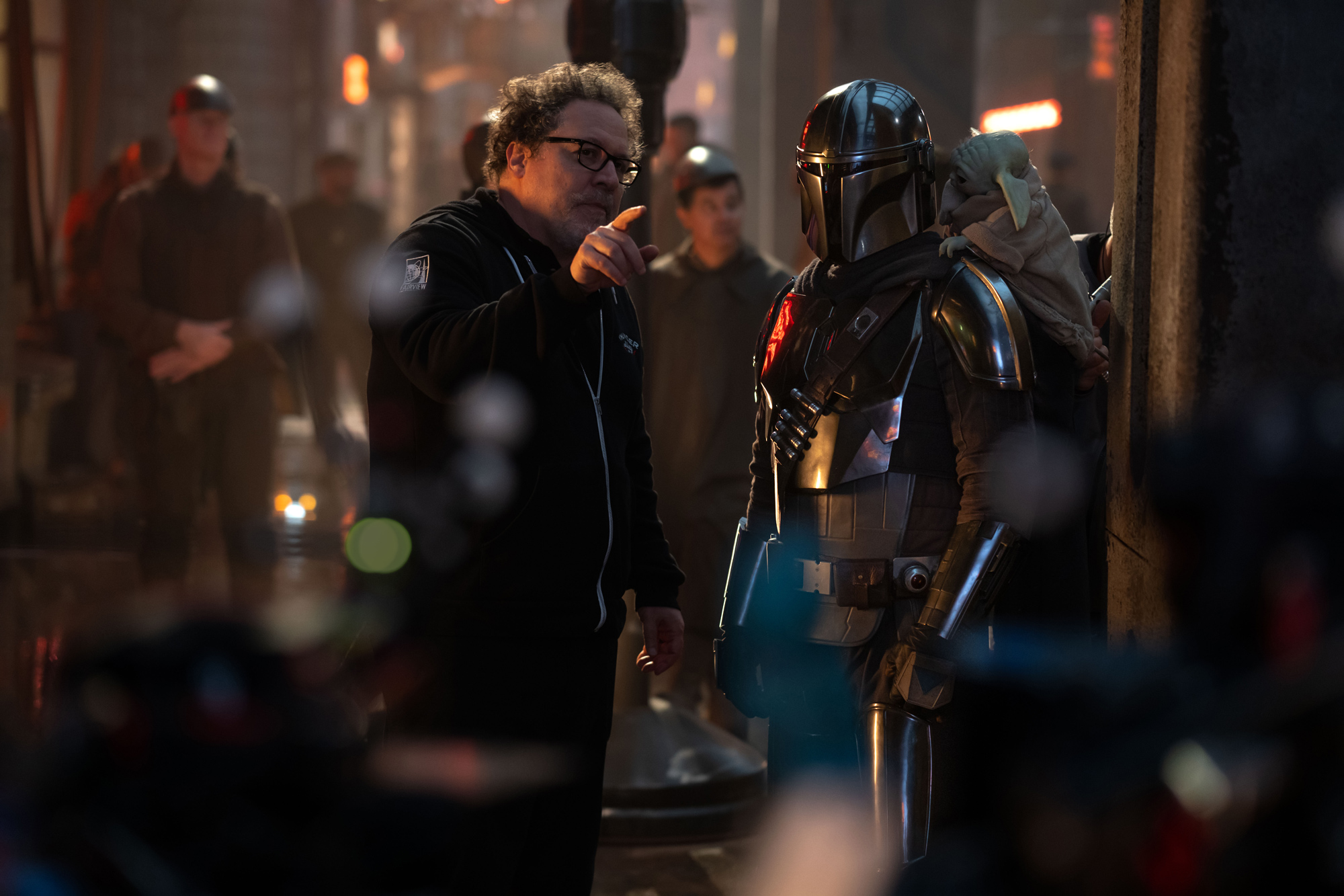 Jon Favreau directs Pedro Pascal as Din Djarin with Grogu on the set of Star Wars: The Mandalorian and Grogu