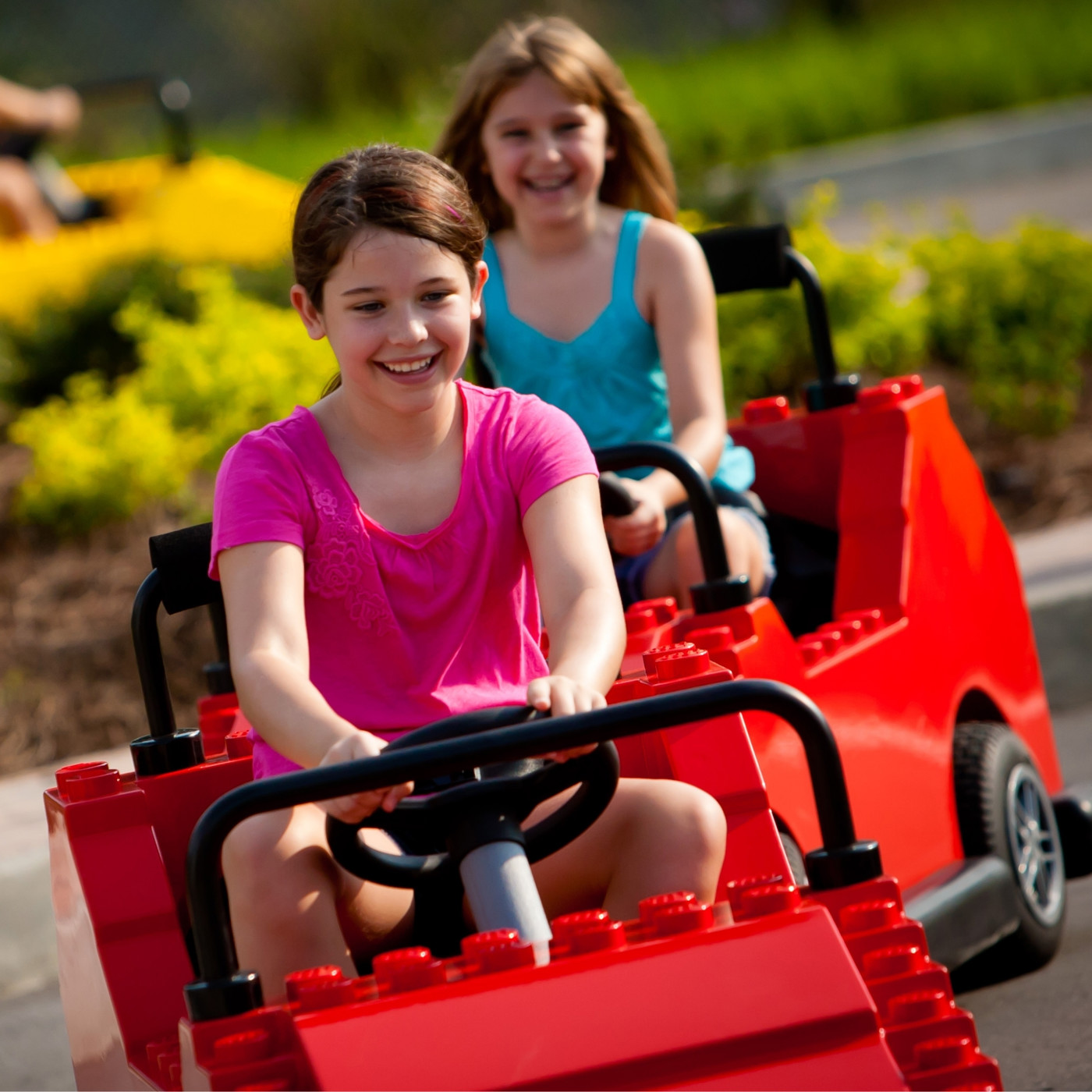 Two children drive LEGO-style cars at Driving School at LEGOLAND Florida.