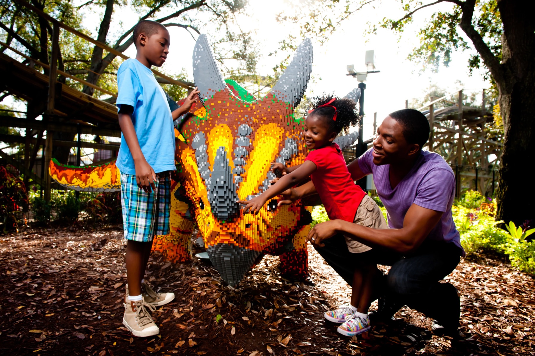 A family posing with a LEGO dinosaur beside Coastersaurus at LEGOLAND Florida Resort