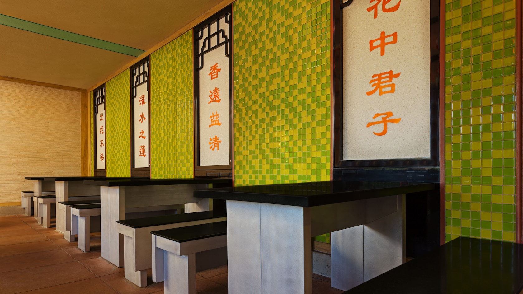 Tables and benches inside a covered Lotus Blossom Café dining room