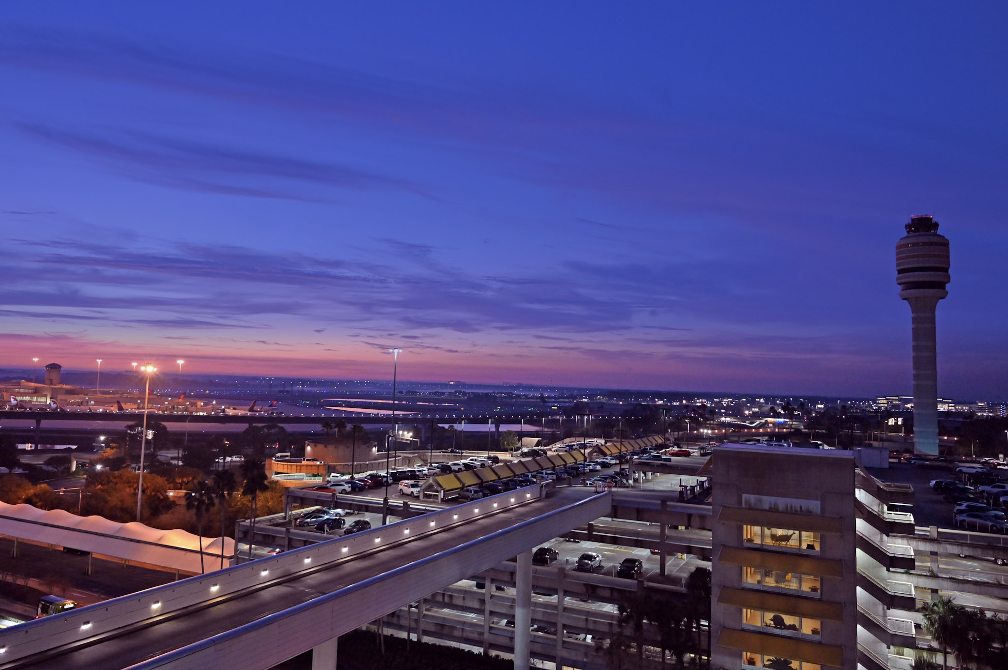 Orlando International Airport at dusk with the control tower and terminal roadways